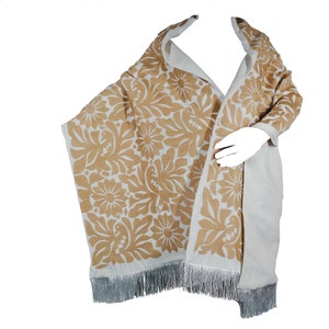 May include: A white shawl with a brown floral pattern and fringe. The shawl is made of a soft, lightweight fabric and is perfect for adding a touch of elegance to any outfit.
