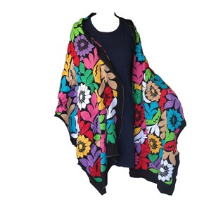 May include: A black shawl with colorful embroidered flowers. The shawl is made of a soft, lightweight fabric and is perfect for adding a touch of color to any outfit.