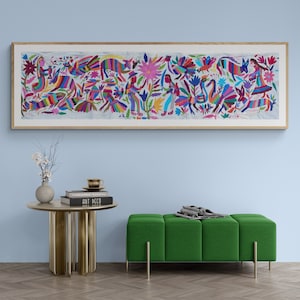 Puede incluir: Una pieza de arte mural enmarcada de forma rectangular larga que presenta un bordado vibrante y multicolor sobre un fondo blanco. El diseño muestra figuras estilizadas de personas, varias aves, animales y grandes elementos florales en tonos brillantes de rosa, azul, verde y rojo.