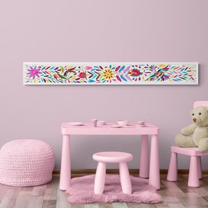 Puede incluir: Un conjunto de mesa y silla de juego rosa para niños con un arte de pared bordado colorido con flores y pájaros. La mesa y la silla están hechas de plástico y tienen un acabado liso y brillante.