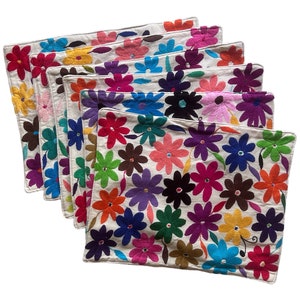 May include: Set of eight colorful embroidered placemats featuring a floral design. The placemats are made of white fabric with multi-colored flowers and leaves.