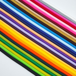 May include: An assortment of brightly coloured cords, including shades of green, orange, yellow, purple, and blue. The cords are arranged diagonally, creating a vibrant display. These cords are likely used for crafts or jewellery making.
