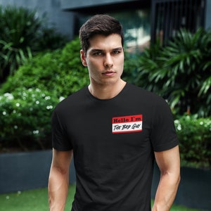 Puede incluir: Un hombre con una camiseta negra con una etiqueta de nombre roja que dice "Hello I'm The Bad Guy".