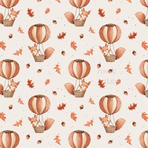 May include: A repeating pattern featuring watercolor illustrations of squirrels in hot air balloons. The balloons are brown and white, and the squirrels are in woven baskets. Scattered around are orange leaves and acorns on a cream background.