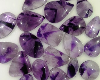 May include: A collection of 20 amethyst cabochons in various shapes and sizes. The cabochons are a deep purple colour with white and black striations.