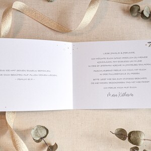 May include: A white card with a blue floral design and text in German. The text reads "Denn er hat seinen Engeln befohlen, dass sie dich beh&uuml;ten auf allen deinen Wegen." - Psalm 91:11 -  Liebe Familie & Freunde, Ich m&ouml;chte euch ganz herzlich zu meiner Kommunion am 15.08.2022 um 11 Uhr in der St. Stephan-Kirche in Hamburg einladen.  Anschlie&szlig;end freue ich mich mit euch in der Pulverm&uuml;hle zu feiern. Bitte gebt mir bis zum 01.07.2022 Bescheid, ob ihr diesen besonderen Tag mit mir feiert. Ich freue mich auf euch.  Maria Katharina"