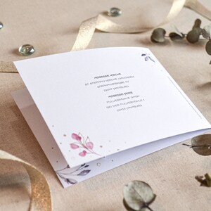 May include: A white card with a floral design and gold accents. The text on the card reads "Adresse Hochzeit" and "Adresse Feier".