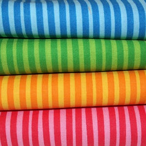 Könnte beinhalten: Nahaufnahme von vier Stoffmustern mit vertikalen Streifen. Die Farben sind Blau, Grün, Orange und Rosa. Jeder Stoff hat ein sich wiederholendes Muster aus Streifen in verschiedenen Farbtönen derselben Farbe. Die Stoffe sind übereinander gestapelt.