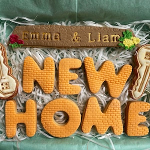 The Housewarming gift cookie box comes with a cookie representing a roof - this can be personalised.  Two house key cookies and brick textured seven letter cookies spelling New Home