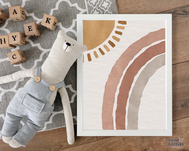 May include: A framed print with a watercolor illustration of a rainbow and sun in shades of brown, pink, and gray. The print is on a white background and has a white frame.