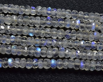May include: A strand of iridescent white moonstone beads. The beads are faceted and have a slightly irregular shape. They are strung on a clear thread.