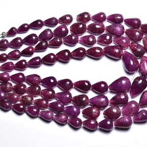 May include: A strand of deep purple gemstone beads, each bead is shaped like a teardrop. The beads are strung on a thin wire and are arranged in a loose, flowing pattern.