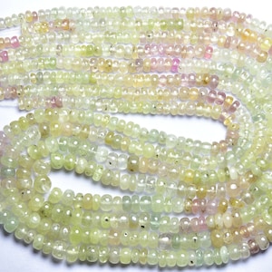 May include: A strand of light green, yellow, and pink gemstone beads. The beads are faceted and have a slightly irregular shape. The beads are strung on a clear thread.