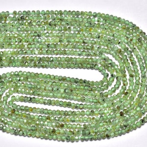 May include: A strand of green gemstone beads, faceted and with a slightly irregular shape. The beads are strung on a thread and are ready to be used for jewellery making.