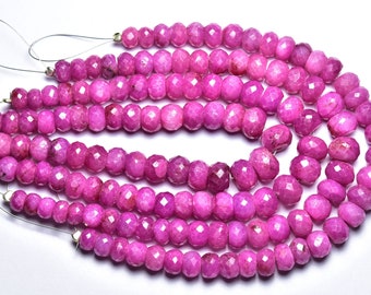 May include: A strand of pink faceted gemstone beads. The beads are round and have a smooth, polished finish. The beads are strung on a silver wire.
