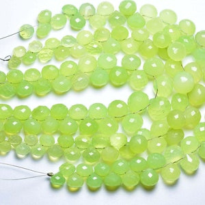 Könnte beinhalten: Eine Strähne aus hellgrünen Edelsteinperlen, facettiert und rund, auf einem Silberdraht aufgereiht. Die Perlen sind in einem lockeren, fließenden Muster angeordnet.