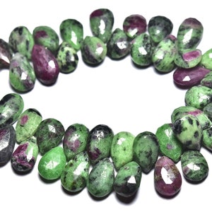 K&ouml;nnte beinhalten: Eine Kette aus gr&uuml;nen, rosa und schwarzen Edelsteinperlen. Die Perlen sind birnenf&ouml;rmig und haben eine facettierte Oberfl&auml;che.