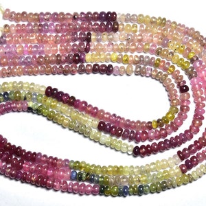 May include: A strand of multi-colored gemstone beads. The beads are round and have a smooth, polished finish. The colors of the beads include pink, red, yellow, green, and blue.