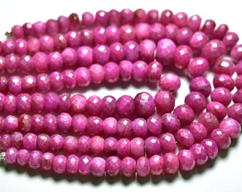 May include: A strand of pink ruby beads, faceted and round, with a polished finish. The beads are strung on a wire and are ready to be used for jewelry making.