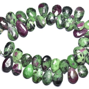 K&ouml;nnte beinhalten: Eine Kette aus gr&uuml;nen und rosafarbenen Edelsteinperlen. Die Perlen sind birnenf&ouml;rmig und haben eine marmorierte Optik.