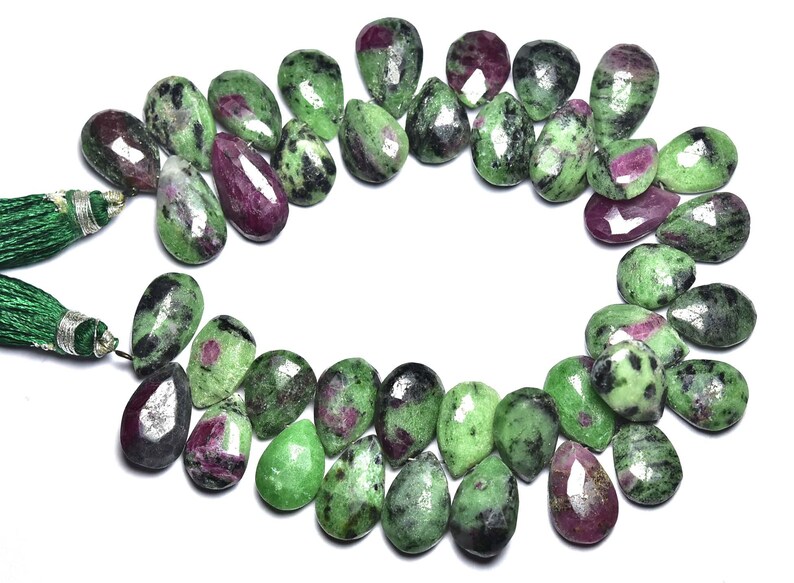 K&ouml;nnte beinhalten: Eine Kette aus gr&uuml;nen und rosafarbenen Edelsteinperlen. Die Perlen sind birnenf&ouml;rmig und haben eine marmorierte Optik.