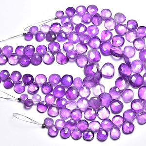 Può includere: Una collana di perle di pietra preziosa ametista, sfaccettate e lucidate, in tonalità viola. Le perle sono infilate su un filo sottile e sono pronte per essere utilizzate per la creazione di gioielli.