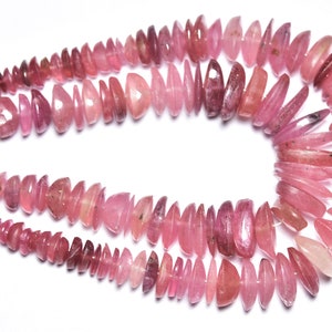 May include: A strand of pink tourmaline beads, each bead is a unique, faceted, and elongated shape. The beads are strung on a silver wire.