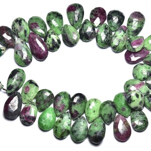 Może przedstawiać: Szereg zielonych i różowych koralików z kamieni szlachetnych, każdy koralik ma kształt gruszki. Koraliki są ułożone w kółko na białym tle.