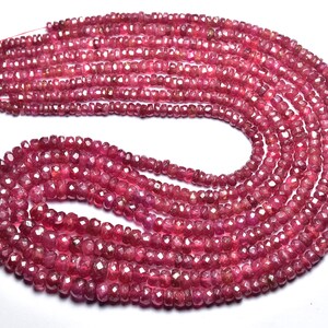Peut inclure: Un brin de perles de pierres précieuses rouge rubis, facettées et enfilées sur un fil fin. Les perles sont petites et de taille uniforme, créant un look délicat et élégant.