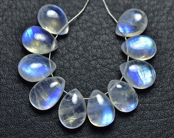 May include: A strand of teardrop-shaped moonstone beads. Each bead is translucent with a milky white base and iridescent blue flashes. The beads are strung on a thin, silver-colored wire, perfect for jewelry making.