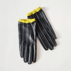 Short edgy leather gloves cool pinstripes with signal color yellow, fitting soft lambskin lined with silk, sporty ruffled