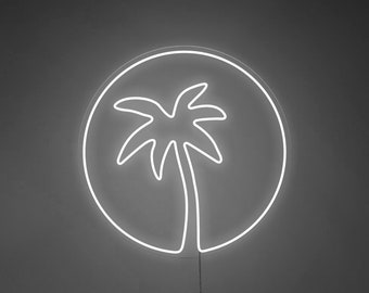 Könnte beinhalten: Ein weißes Neon-Schild in Form eines Kreises mit einer Palme darin. Das Schild hängt an einer dunklen Wand über einem grauen Sofa mit zwei Kissen.