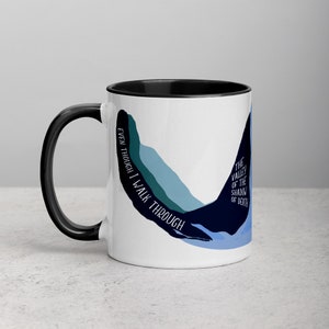 May include: White ceramic mug with a black rim and handle. The mug features a blue and green abstract design with the text "Even though I walk through the valley of the shadow of death" on the side.