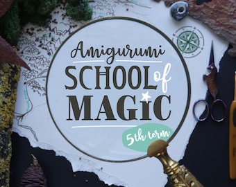Peut inclure: Un cercle blanc avec le texte "Amigurumi School of Magic" en lettres noires et une étoile blanche. Sous le texte se trouve un cercle turquoise avec le texte "5th term" en lettres blanches. Le cercle est entouré d'un cadre en bois brun et se trouve sur un fond blanc.