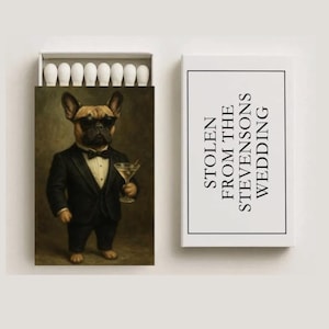May include: Matchbox with a humorous illustration of a French Bulldog in a tuxedo and sunglasses, holding a martini. The matchbox reads "Stolen from the Stevensons Wedding". The box is white with a black border.