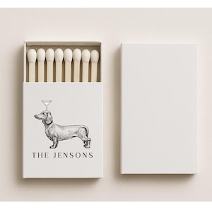 May include: A white matchbox with a black and white illustration of a dachshund with a martini glass on its head. The text "THE JENSONS" is below the dog. The box is open, revealing matches.