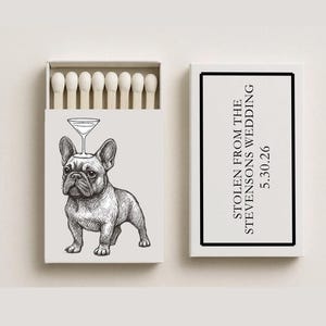 May include: A matchbox with a black and white illustration of a French Bulldog with a martini glass on its head. The text "STOLEN FROM THE STEVENSONS WEDDING 5.30.26" is on the side of the box. The match heads are visible.