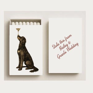May include: Matchbox with a dog illustration balancing a cocktail glass on its nose. The matchbox has the text "Stole this from Bailey & Grant's Wedding" on the cover. The matchbox contains white matchsticks.