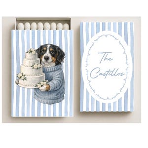 May include: Matchbox with a watercolor illustration of a dog holding a tiered cake, wearing a blue sweater. The matchbox has a blue and white striped design. The text "The Castillos" is on the adjacent matchbox.