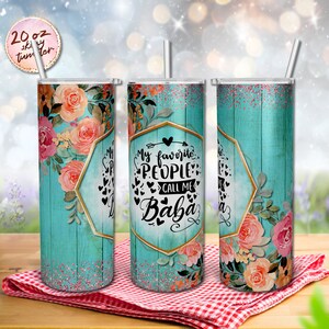 May include: A 20 ounce stainless steel tumbler with a teal and white woodgrain design. The tumbler features a floral design with pink and peach flowers. The text "My favourite people call me Baba" is printed on the tumbler.