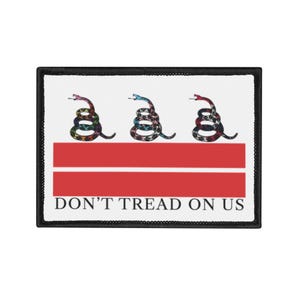 Pode incluir: Remendo retangular com fundo branco, apresentando três cobras enroladas acima de duas faixas vermelhas horizontais. As cobras têm padrões coloridos. O texto "DON'T TREAD ON US" está impresso em preto abaixo. O remendo tem uma borda preta.