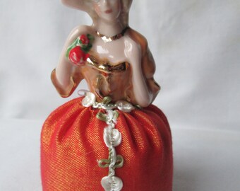 Alfiletero de media muñeca de porcelana con vestido rojo