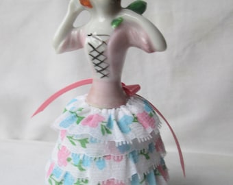 Alfiletero de media muñeca de porcelana con vestido de flores