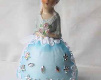 Alfiletero de media muñeca de porcelana con vestido azul