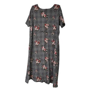 May include: A knee-length dress with short sleeves, featuring a black and white plaid pattern. The dress is adorned with clusters of pink and red floral designs, creating a contrast against the checkered background. The dress has a scoop neckline.
