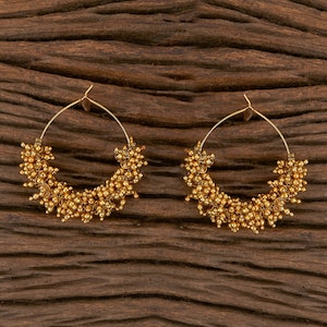 May include: A pair of gold hoop earrings with a cluster of small gold beads around the circumference.