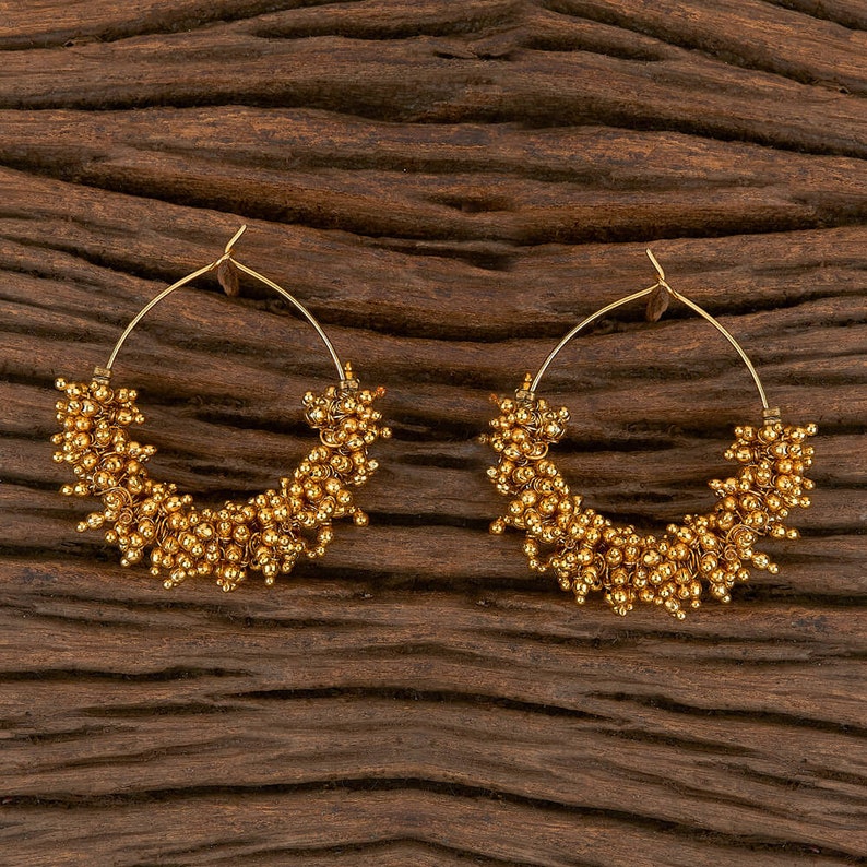 May include: A pair of gold hoop earrings with a cluster of small gold beads around the circumference.