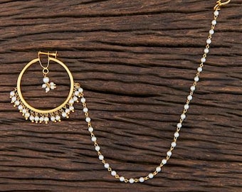 May include: Gold nose ring with a pearl chain and a dangling pearl cluster. The nose ring is a hoop with a small pearl pendant.