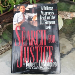 May include: A black hardcover book titled "The Search for Justice: A Defense Attorney's Brief on the O.J. Simpson Case" by Robert L. Shapiro with Larkin Warren. The cover features a photo of Robert L. Shapiro.