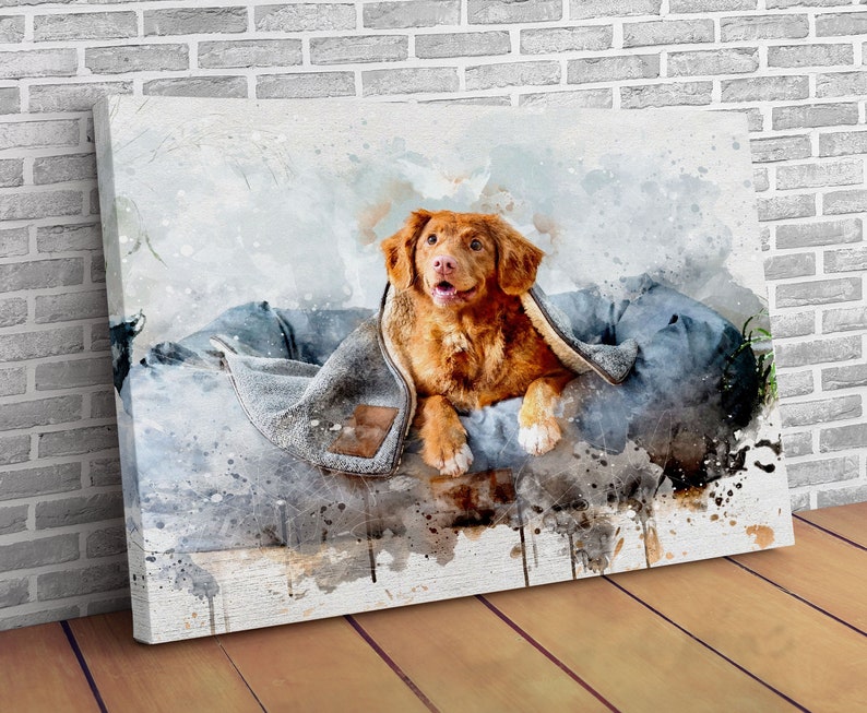 May include: Watercolor-style canvas print featuring a golden-brown dog, partially wrapped in a gray blanket. The dog is lying on a blue dog bed, with a happy expression. The background has watercolor splashes.